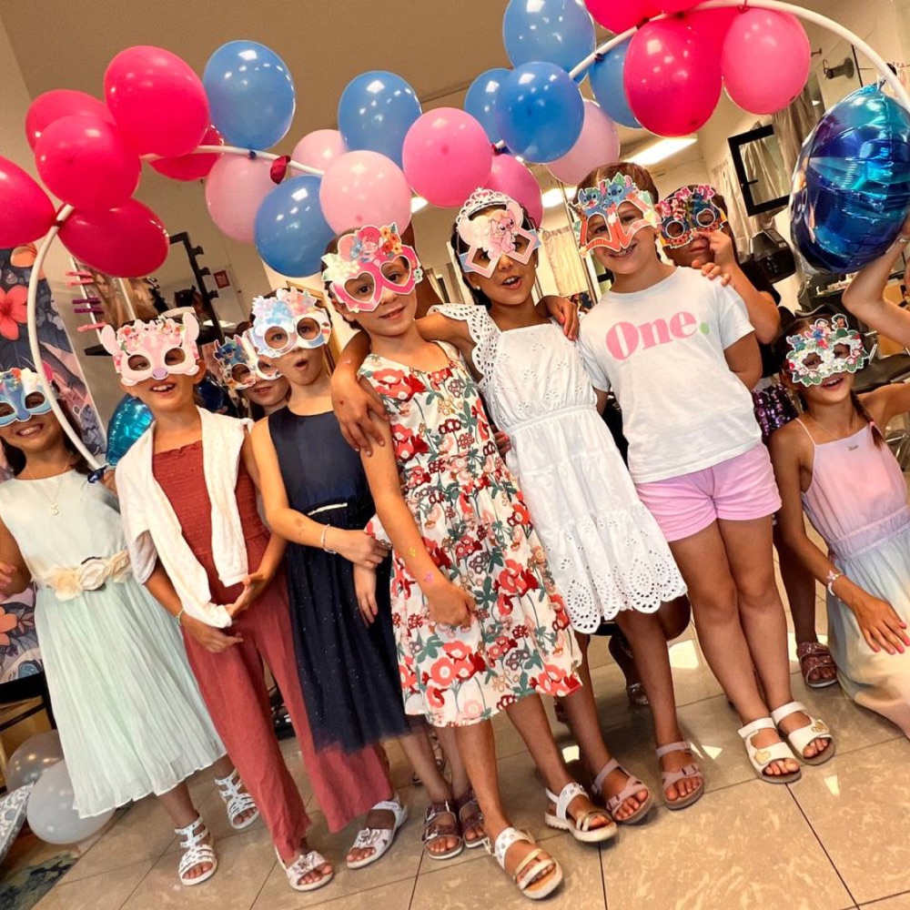 Gruppo di bambine con maschere a tema e palloncini al compleanno principesse