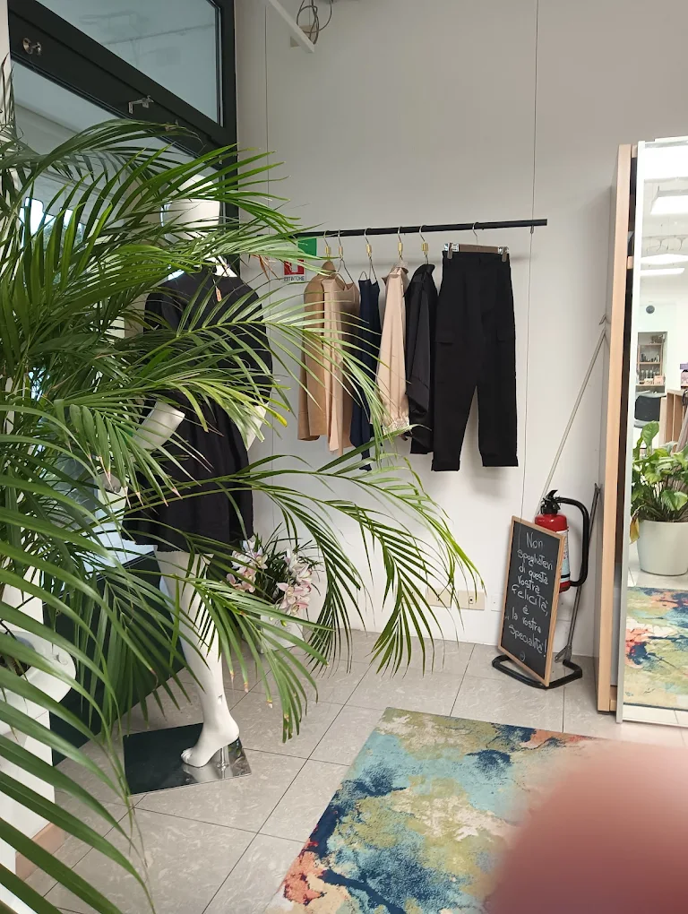Angolo abbigliamento del salone con rack di vestiti, manichino e piante